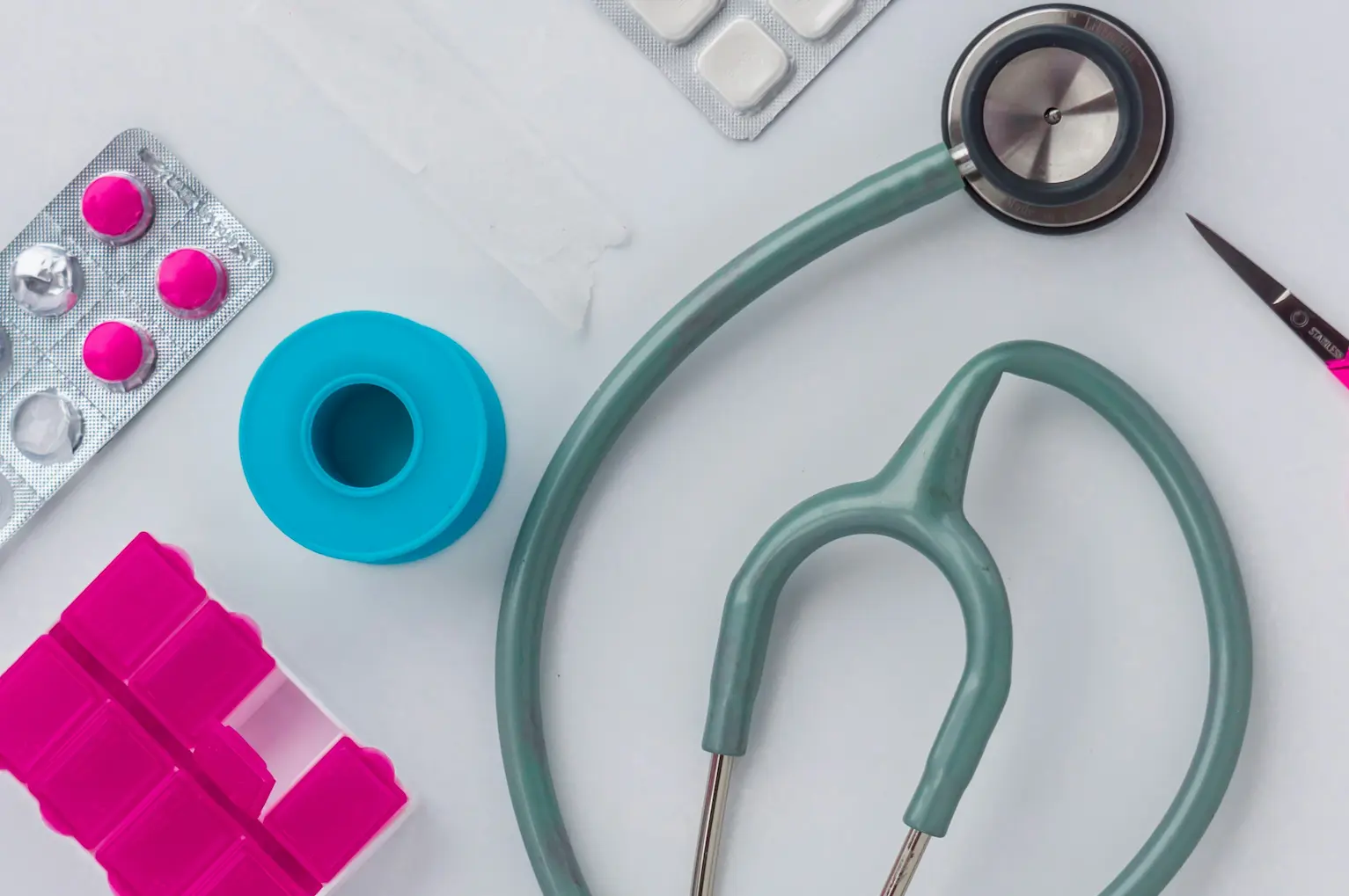 Stethoscope, pills, medical tape on a desk